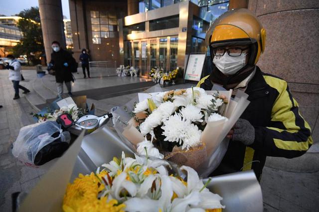 2月7日，武汉中心医院后湖院区门诊楼门口，无法前来的市民委托外卖员献花。.jpeg