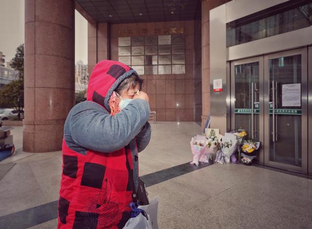 2月7日，武汉中心医院后湖院区门诊楼门口，前来悼念的市民擦拭眼角的泪水。.jpeg