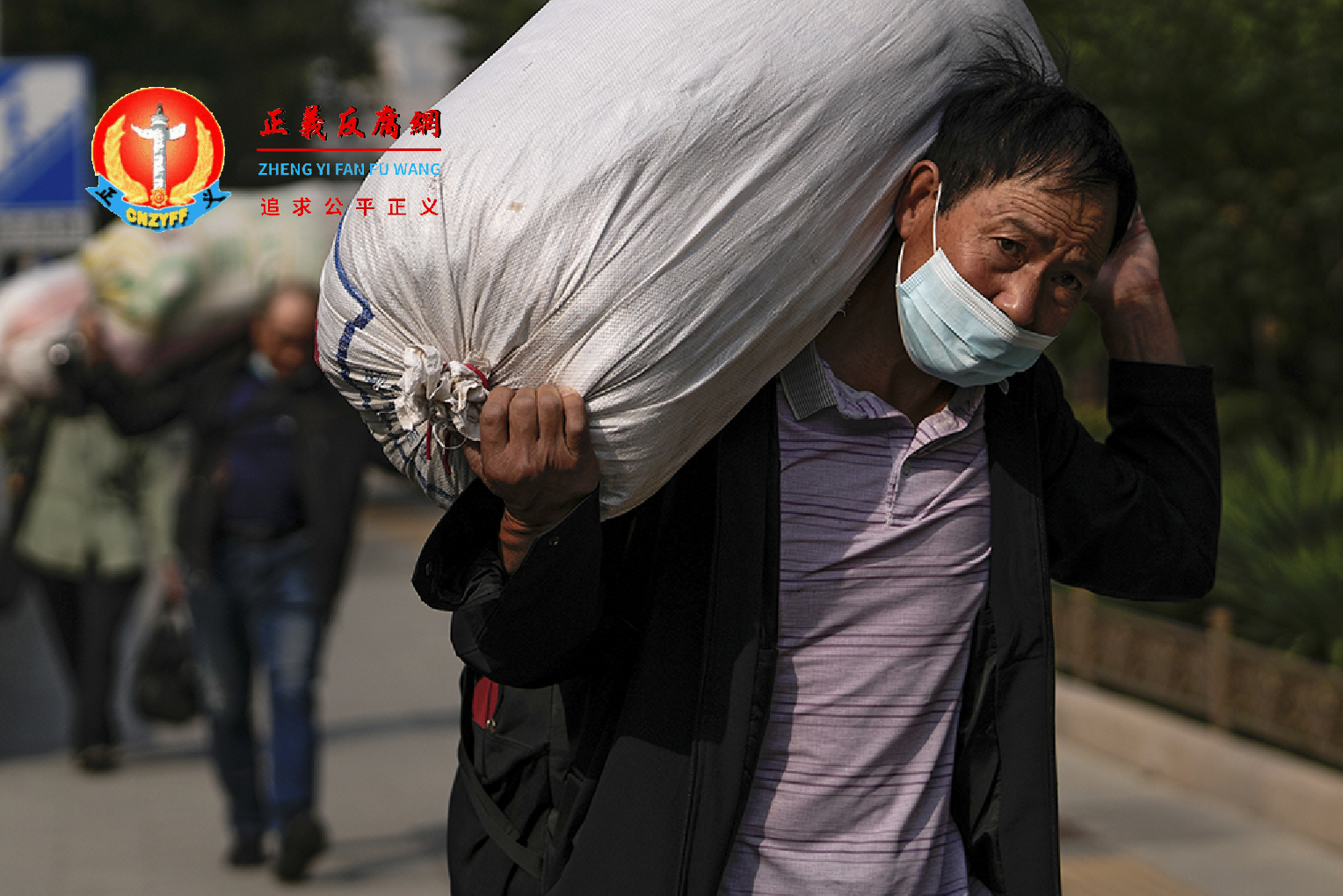 农民工背负重袋，走在北京街头。摄于2022年9月27日。.png
