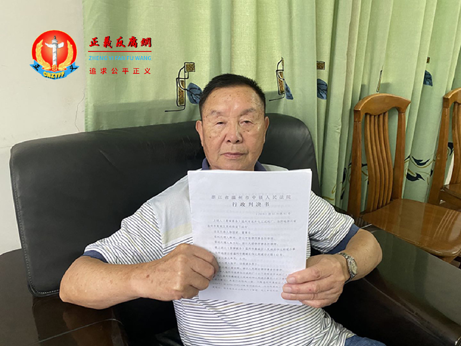 2021年80岁的徐国梁手持温州中级人民法院的行政判决书。.png